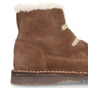 Suede leather kids ankle boots with laces and fake hair lined.